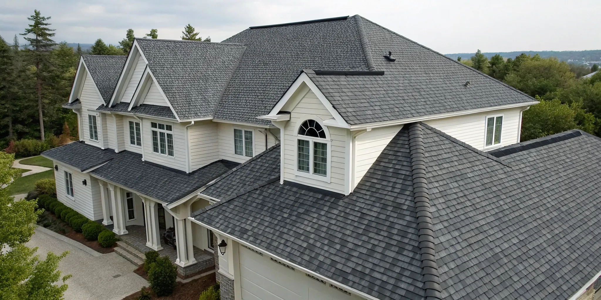 Gray architectural asphalt shingles with a dimensional texture on the roof of a modern home.
